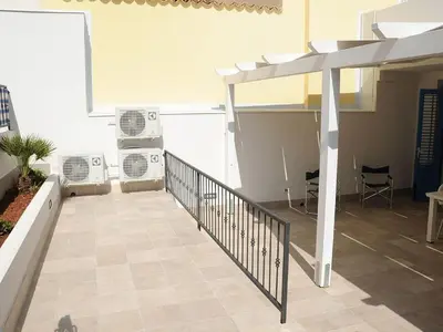 a living room with a staircase and a kitchen at Appartamento Irma Dario in San Vito lo Capo