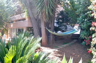 a hammock hanging from two trees in a garden at Casa Frida in Palermo