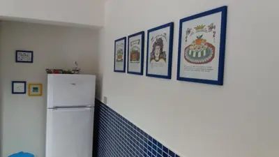 a kitchen with a refrigerator and pictures on the wall at Casa Frida in Palermo