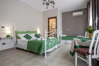 a bedroom with a green and white bed and two tables at Villa Salvatore in Capaci