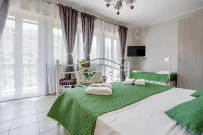 a bedroom with a green and white bed and windows at Villa Salvatore in Capaci