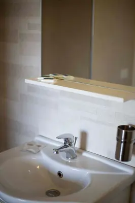 a white bathroom sink with a mirror and a sink at Elisir Suite Rooms by Marino Tourist in San Vito lo Capo