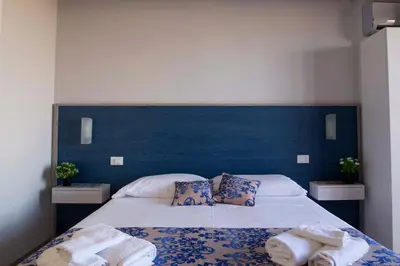 a bedroom with a blue headboard and a bed with towels at Elisir Suite Rooms by Marino Tourist in San Vito lo Capo