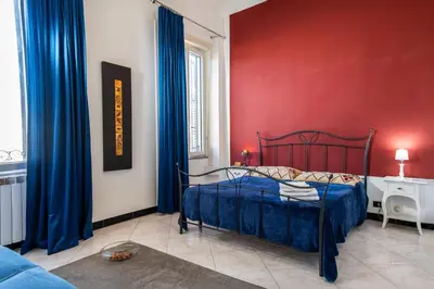 a bedroom with a bed and a red wall at Ai quattro canti di città, appartamento in centro in Palermo