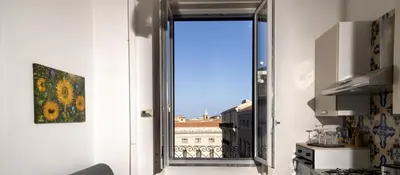 an open door to a balcony with a view of a building at Ai quattro canti di città, appartamento in centro in Palermo