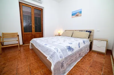 a bedroom with a bed and a table and a window at Villa Linda, Exceptional Sea-view in Terrasini