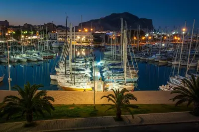 a group of boats docked in a marina at night at Ci'Cala House in Palermo