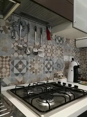 a stove top in a kitchen with utensils on the wall at B&B A casa dell'artista in Casteldaccia