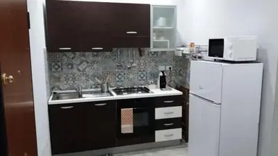 a kitchen with a sink and a white refrigerator at B&B A casa dell'artista in Casteldaccia