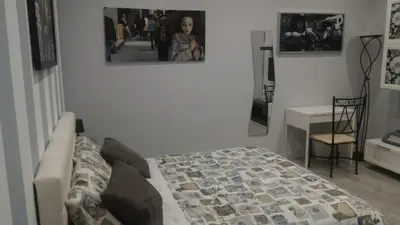a bedroom with a bed and a table and a mirror at B&B A casa dell'artista in Casteldaccia