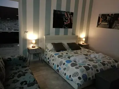 a bedroom with a bed and two lamps on two tables at B&B A casa dell'artista in Casteldaccia