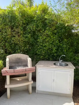 a sink and a chair sitting next to a table at Villetta Azzurra in Alcamo Marina