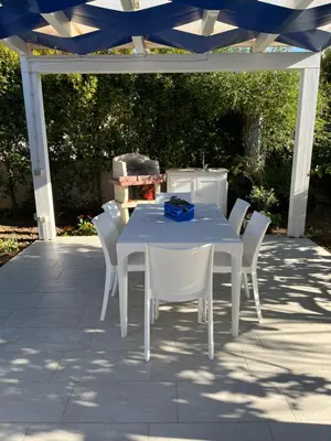 a white table and chairs under a white pergola at Villetta Azzurra in Alcamo Marina