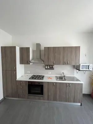 a kitchen with wooden cabinets and a stove top oven at Villetta Azzurra in Alcamo Marina