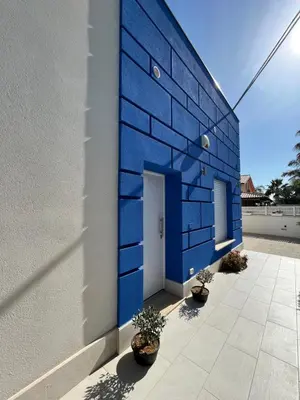 a blue building with potted plants in front of it at Villetta Azzurra in Alcamo Marina