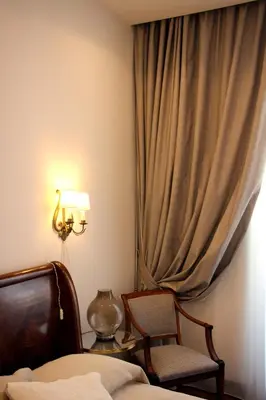 a bedroom with a bed and a chair and a window at B&B Vivere Palermo in Palermo