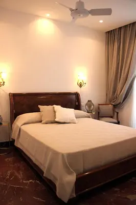 a bedroom with a bed with two lamps and two chairs at B&B Vivere Palermo in Palermo