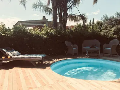a swimming pool in a yard with chairs and a table at Villa Rosemada, Mondello in Palermo