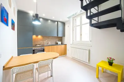 a kitchen with a wooden table and chairs at Loft 18 by Wonderful Italy in Palermo