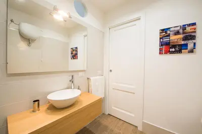 a bathroom with a white bowl sink on a wooden counter at Loft 18 by Wonderful Italy in Palermo