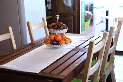 a kitchen with a table with chairs and a refrigerator at Jardin De France in Palermo