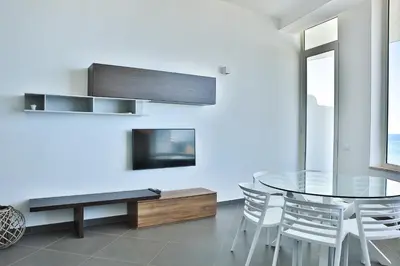 a dining room with a glass table and a tv at Hotel Sporting Club in Altavilla Milicia