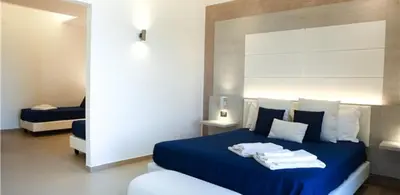 a bedroom with a blue bed with towels on it at Hotel Sporting Club in Altavilla Milicia
