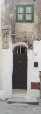 a black door on a building with a green window at Room holiday 