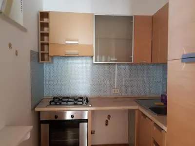 a kitchen with wooden cabinets and a stove top oven at Boutique House Montevergini in Palermo