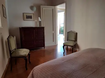 a bedroom with two chairs and a bed and a dresser at Boutique House Montevergini in Palermo