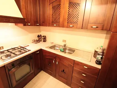 a kitchen with wooden cabinets and a sink and a stove at Orologio del Massimo in Palermo