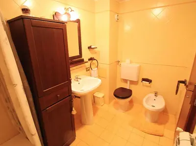 a bathroom with a sink and a toilet and a mirror at Orologio del Massimo in Palermo