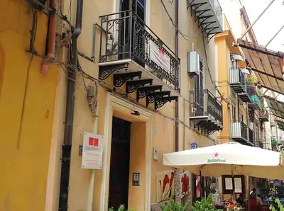 a building with a balcony and an umbrella at Orologio del Massimo in Palermo