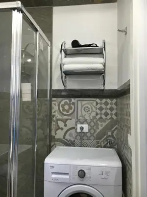 a bathroom with a washing machine and a shower at Le Case di Palma - Viola in San Vito lo Capo
