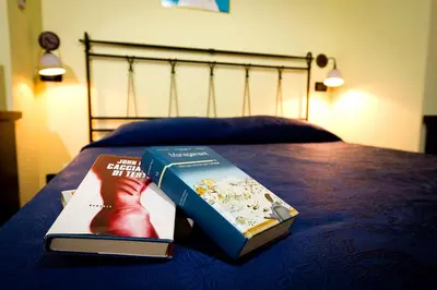 two books sitting on top of a bed at La Chiusa Case Vacanze in Castellammare del Golfo