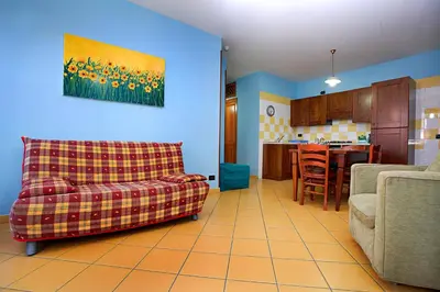 a living room with a couch and a kitchen at La Chiusa Case Vacanze in Castellammare del Golfo