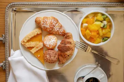 a plate of food with bread and a bowl of fruit at Palazzo Brunaccini Boutique Hotel in Palermo