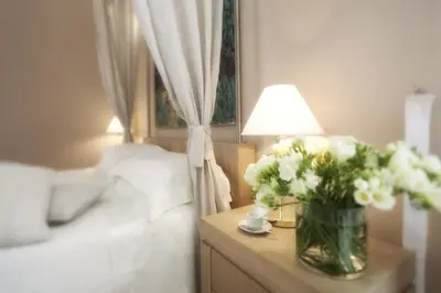 a bedroom with a table with a vase of flowers at Palazzo Brunaccini Boutique Hotel in Palermo
