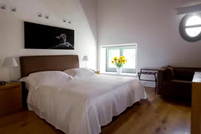 a bedroom with a white bed and a vase of flowers at Palazzo Brunaccini Boutique Hotel in Palermo