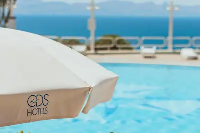 a bed in front of a swimming pool at CDSHotels Terrasini - Città del Mare in Terrasini