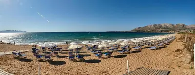 a group of chairs and umbrellas on a beach at CDSHotels Terrasini - Città del Mare in Terrasini