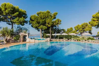 a large swimming pool with trees in the background at CDSHotels Terrasini - Città del Mare in Terrasini