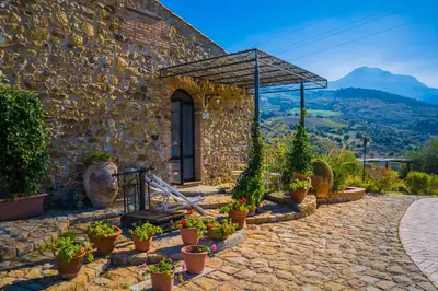 a stone building with a bunch of potted plants at Poggio Pozzetti in Lascari