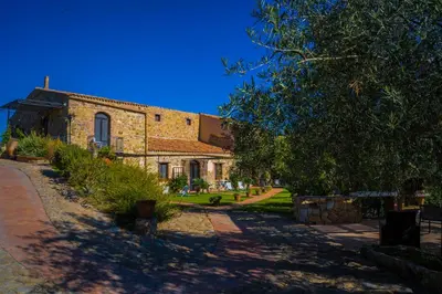 a brick building with a tree in front of it at Poggio Pozzetti in Lascari