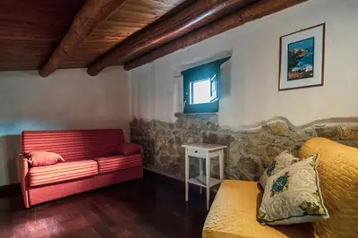a living room with a red couch and a window at Poggio Pozzetti in Lascari
