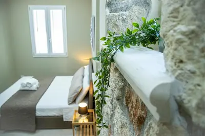 a bedroom with two beds and a stone wall at House Orlando in Sferracavallo