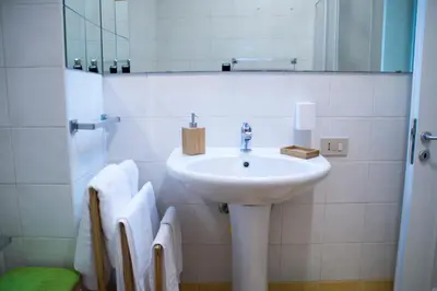 a bathroom with a sink and a mirror and towels at Mediterraneo in Palermo