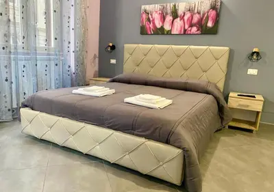 a large bed in a bedroom with pink tulips at Oasi del Turista in Palermo
