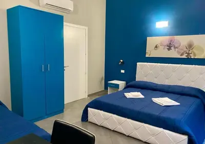 a blue bedroom with a bed and a blue wall at Oasi del Turista in Palermo