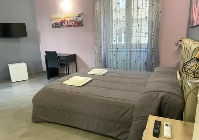 a bedroom with a bed and a table and a couch at Oasi del Turista in Palermo